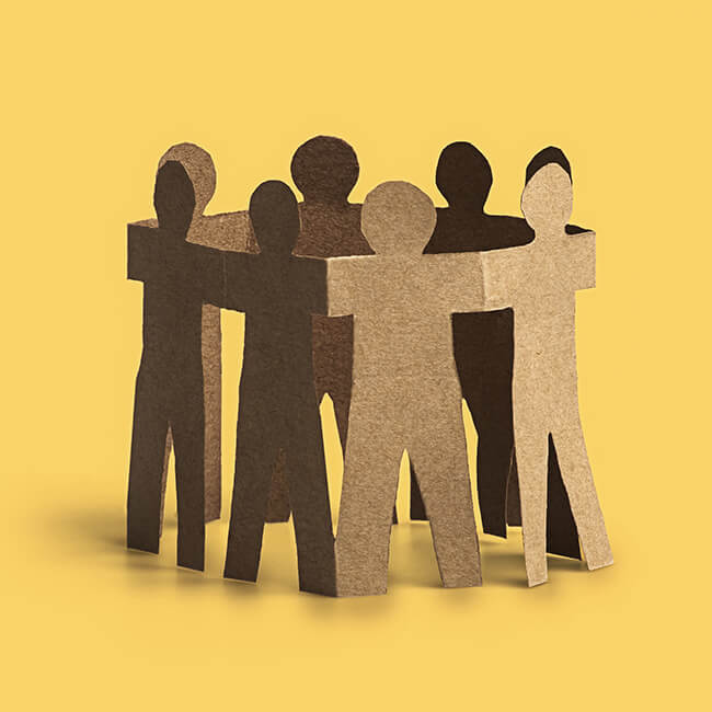 Cardboard cutouts of people in a circle with hands joined