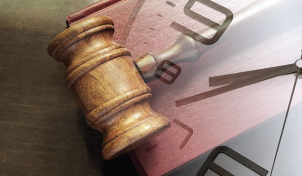 A closeup of a gavel and a clock