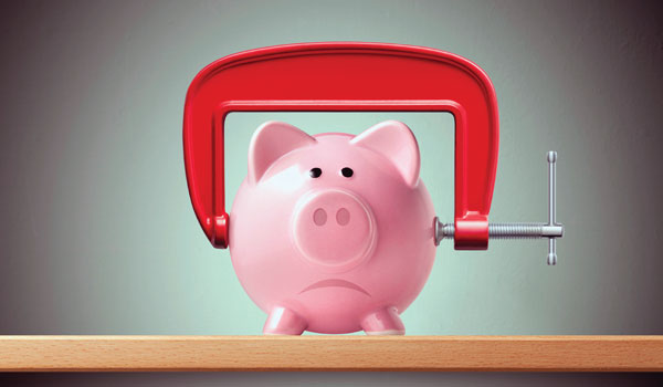 A frowning piggy bank with a clamp on it